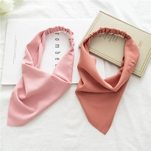 Close-up of pink and brick red elastic headbands on minimalist white background
