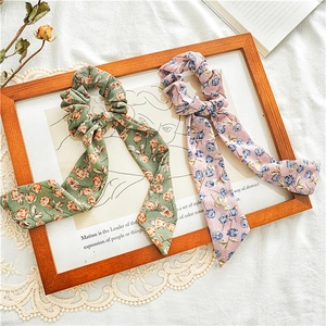 Detail of floral scrunchie with ribbons featuring vintage rose patterns on lace