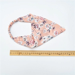 Bandeau élastique rose clair avec motif floral blanc et violet sur un fond blanc pur