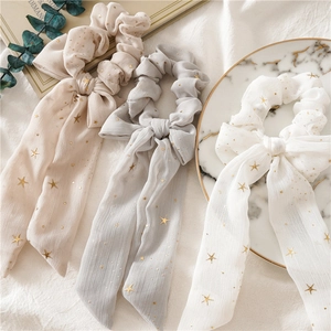 Detailansicht von drei Chiffon-Haargummis mit Sternenmuster und langen Bändern