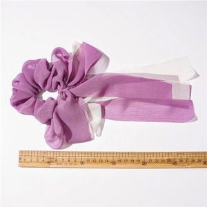 Vue détaillée des chouchous en mousseline violette et blanche avec rubans sur fond blanc