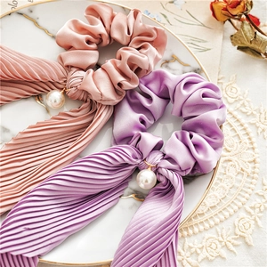 Detail of satin scrunchies with pleated streamers and pearls in pink and purple