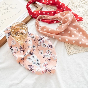 Détail de bandeaux en tissu à fleurs et à pois avec élastiques sur tissu blanc