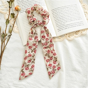 Detail of floral ribbon scrunchie with pink roses on beige silk background