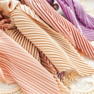 Detailed macro view of pleated satin scrunchies in pastel colors on lace background