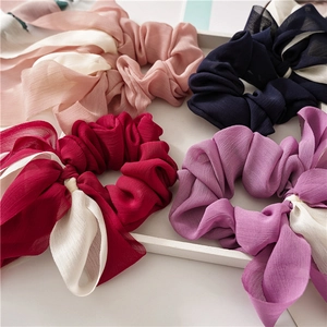 Gros plan de chouchous élégants en mousseline avec rubans en quatre couleurs assorties