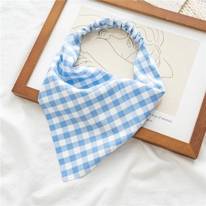 Détail d'un foulard élastique à carreaux bleu et blanc sur cadre en bois rustique