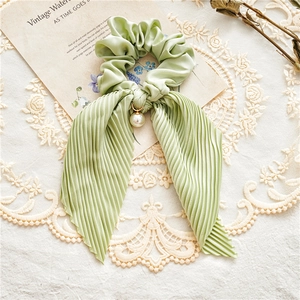 Detail of mint green satin scrunchie with pleated ribbon and pearl pendant charm