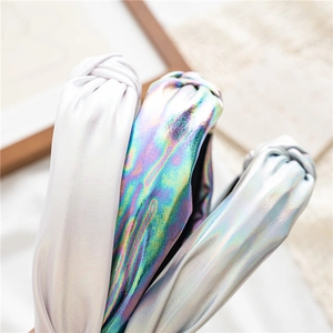 Close-up of three knotted headbands in metallic silver, iridescent and matte purple