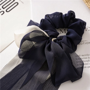 Détail du chouchou en mousseline plissée bleu marine et beige avec longs rubans