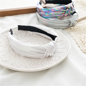 Close-up of shiny knotted wide headbands with metallic finish and anti-slip lining