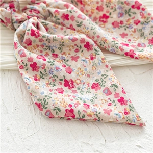 Detailed macro view of the floral print hair scrunchie with long ribbons on white fabric
