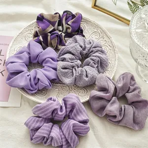 Lot de 5 chouchous violets aux textures variées présentés sur un fond élégant et épuré