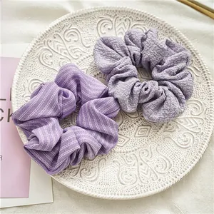 Gros plan de chouchous violets avec textures seersucker et rayures sur une assiette