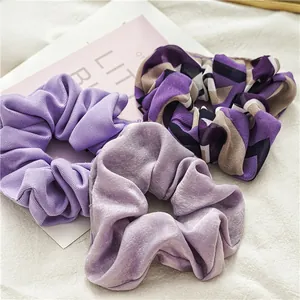 Détail de chouchous violets en velours, tissu côtelé et mousseline de soie à motifs