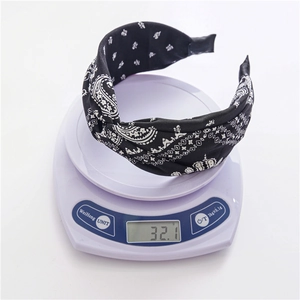 Détail d'un bandeau en tissu noir à motif paisley sur une balance pesant 32,1 g