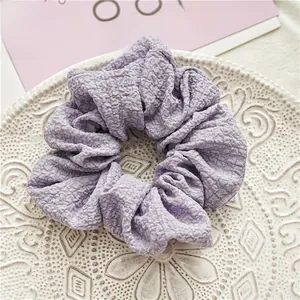 Gros plan d'un chouchou violet clair en seersucker sur une assiette blanche vintage