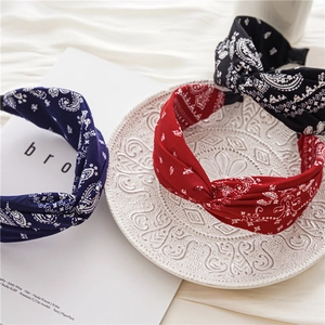Détail de trois bandeaux en tissu à motif paisley avec nœud croisé en bleu, rouge, noir
