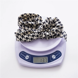 Detail shot showing a lightweight houndstooth scrunchie with long ribbons weighing 13.7g