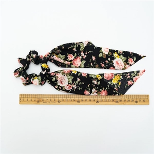 Chouchou floral avec motifs de roses et longs rubans mesurant 32 cm sur fond blanc neutre