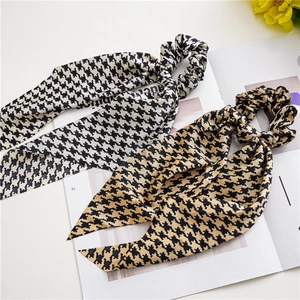 Detailed view of houndstooth silk scrunchies with long ribbons in black and brown colors