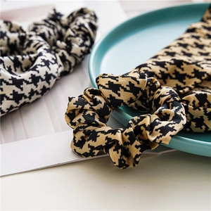Satin houndstooth scrunchies in black-white and yellow-black for elegant hairstyles