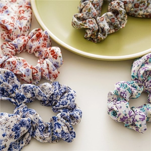 Détail de chouchous à fleurs de différentes couleurs sur fond de plat en céramique