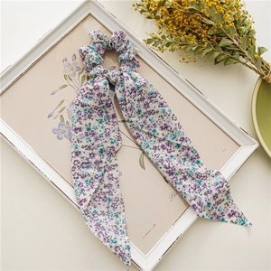 Détail du chouchou floral en mousseline avec longs rubans sur cadre décoratif