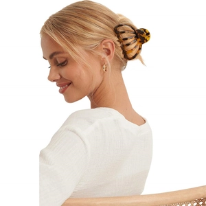 Large leopard print acetate hair claw clip worn by a model for elegant hair styling
