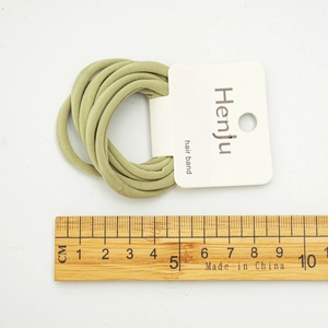 Sage green elastic hair band set with brand card and wooden ruler for size comparison