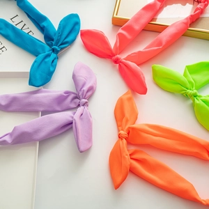 Detail of five fluorescent bunny ear elastic headbands with fabric knot design