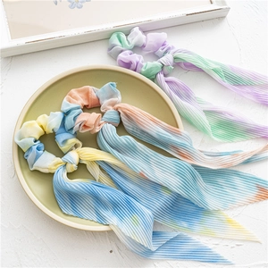 Détail de chouchous plissés tie-dye avec de longs rubans aux dégradés doux