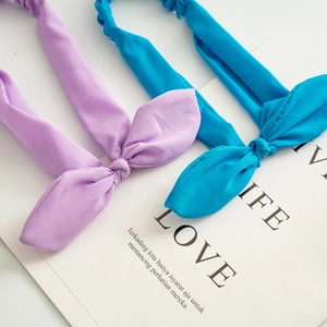 Detailed view of elastic knot headbands in light purple and peacock blue fabric