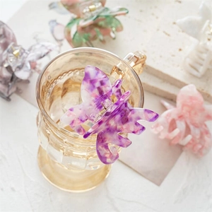 Pince à cheveux papillon en acétate avec texture marbrée sur un verre pour un style élégant
