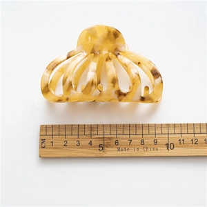 Macro detail of amber tortoiseshell hair claw showing its 8.5cm size against a ruler