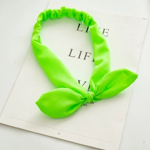 Detail view of neon green rabbit ear headband featuring soft textured fabric and elastic band
