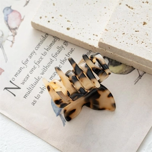 Vue détaillée d'une pince à cheveux papillon en écaille sur un fond esthétique vintage