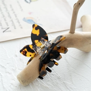 Gros plan détaillé d'une pince à cheveux papillon en écaille avec ressort doré