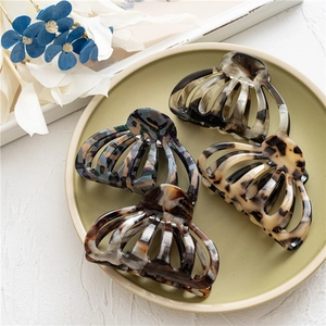 Macro detail of four large cutout hair claws with leopard and tortoiseshell patterns