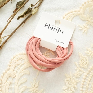 Close-up of pink elastic hair bands on cardboard packaging with decorative lace