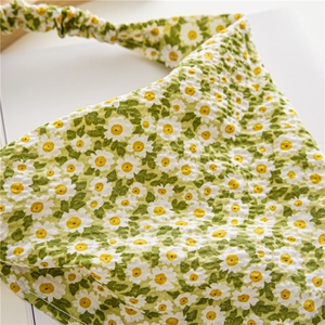 Detail of green floral daisy print triangle hair scarf with elastic band and fabric texture