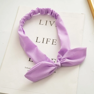 Detail of lavender purple fabric headband featuring rabbit ear bow and elastic texture