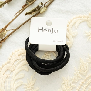 Close-up of black elastic hair band set with brand tag on vintage lace fabric