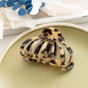 Macro shot of large tortoiseshell acetate hair claw clip on decorative plate