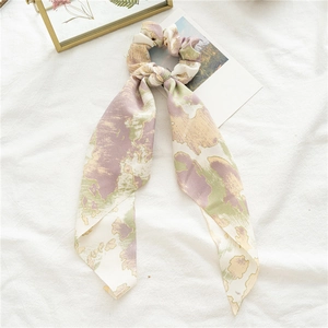 Détail du chouchou en satin avec long ruban aux motifs marbrés tie-dye violets