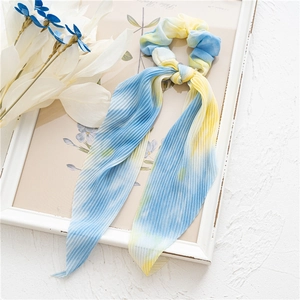 Détail de chouchou plissé tie-dye avec de longs rubans en jaune et bleu clair