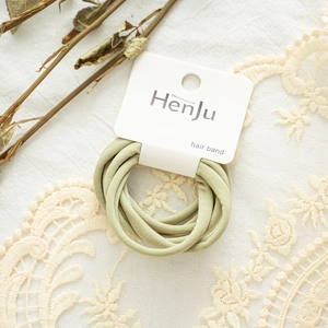 Detail view of light green elastic hair band set with brand tag on lace background