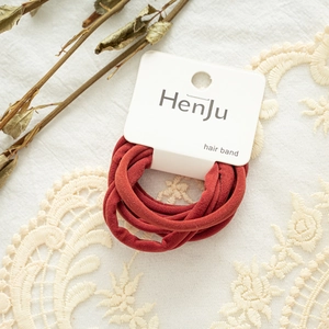 Elastic hair ties in burgundy red displayed on a white branded card for daily styling