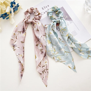 Detailansicht von Haargummis aus Satin mit Blumenmuster und langen Bändern in Pastell