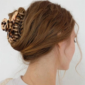 Detailed view of a 10cm leopard print acetate hair claw clip securing a twisted bun